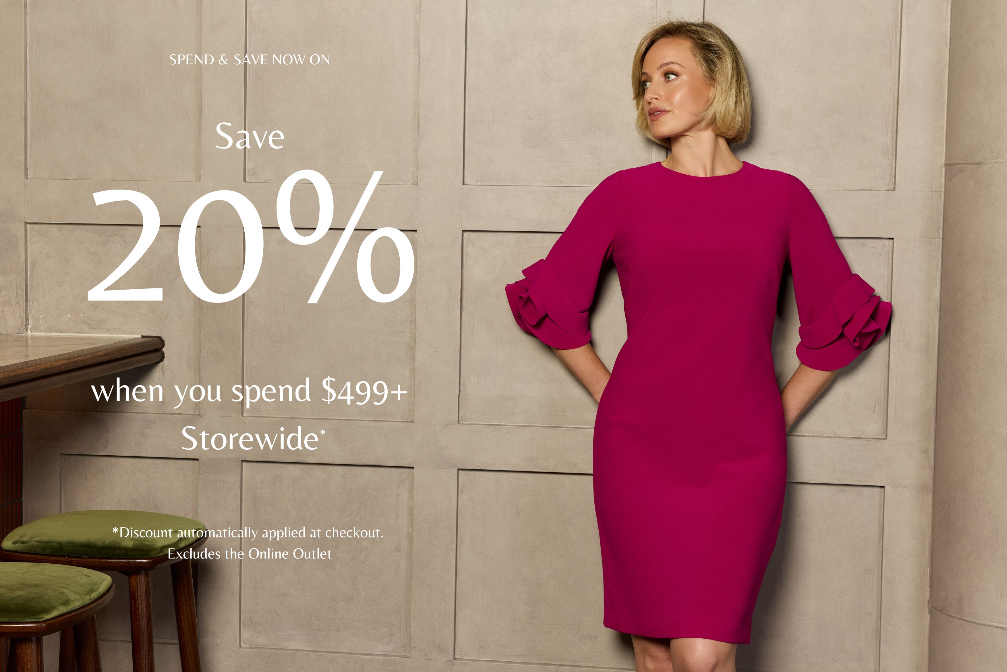 Woman in a pink dress standing against a beige wall with promotional text overlay. Spend & Save Now on | Save 20% when you spend $499 Storewide. Rosie Magenta Crepe Dress.