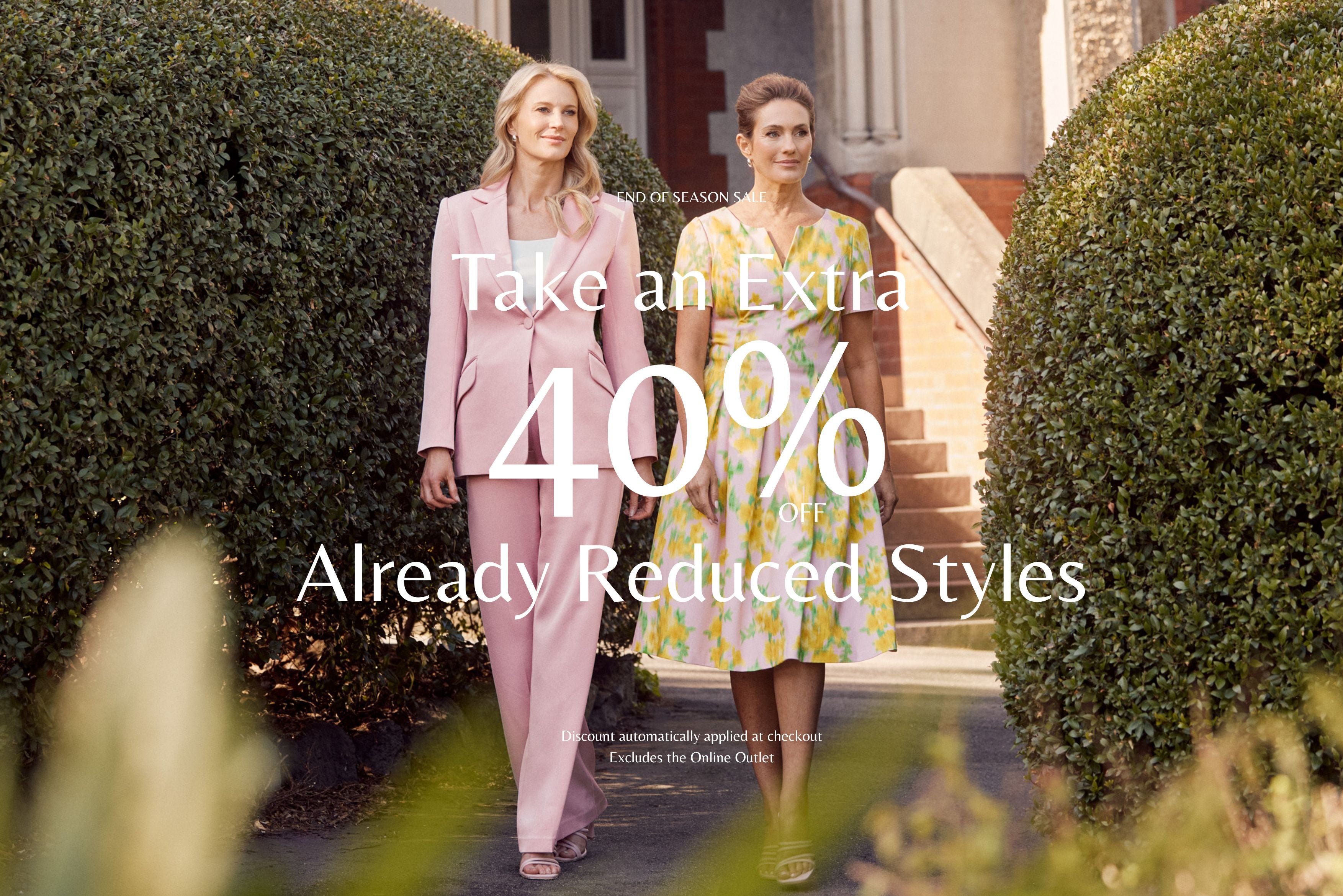 Two women walking outdoors with a promotional text overlay for a discount offer. Take an Extra 40% Off Already Reduced Styles.