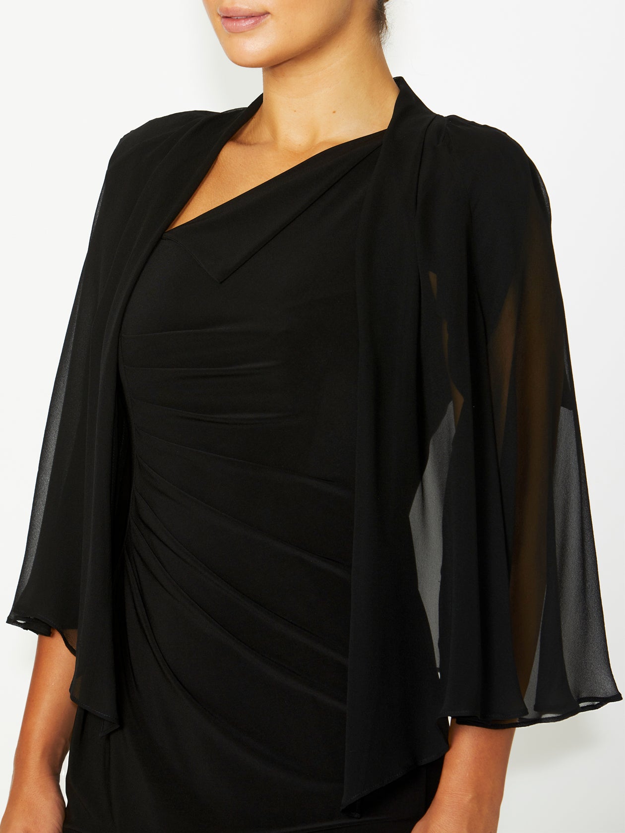 Side angle of Carrie Black Silk Shrug – A side perspective showcasing the shrug’s soft movement and fluid silhouette. The delicate sheer fabric and draped design offer an elegant finishing touch to any outfit.