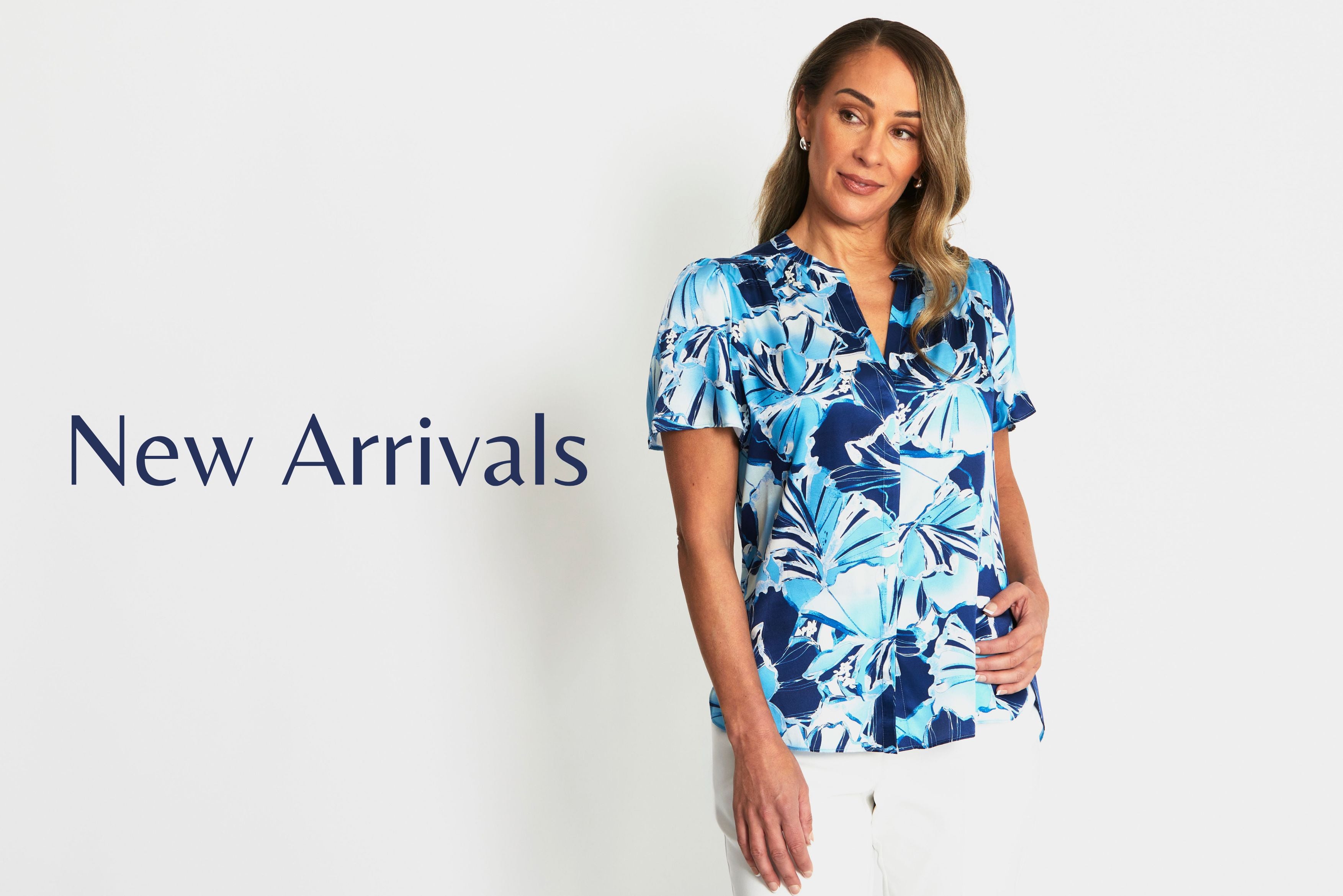 Woman wearing a blue floral blouse with 'New Arrivals' text on a white background. Clover Glacier Silk Top